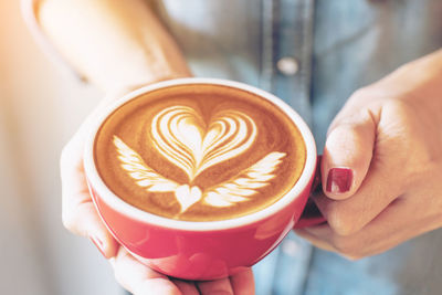 Midsection of man holding coffee cup