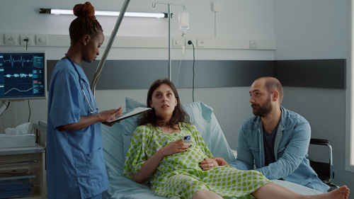 Nurse examining pregnant woman in hospital