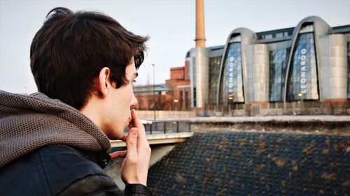 Side view of man smoking cigarette 