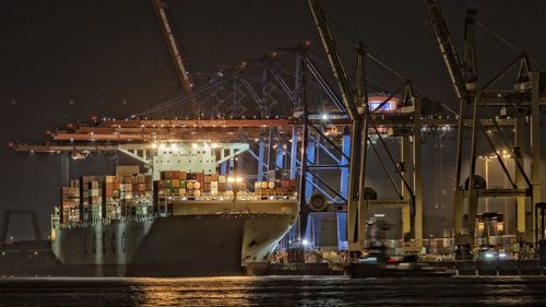 Illuminated harbor against sky at night