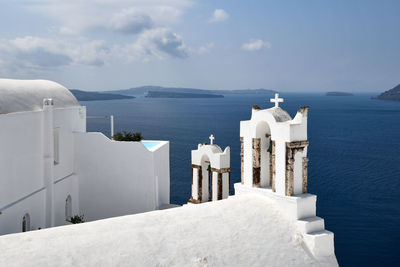 Buildings by sea against sky