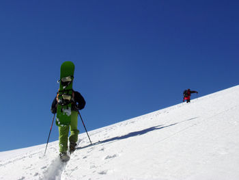 People skiing on snow covered landscape