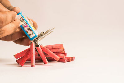 Midsection of woman holding umbrella against white background