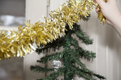 Close-up of hand decorating christmas tree