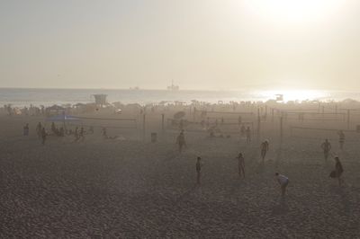 People playing at beach against sky