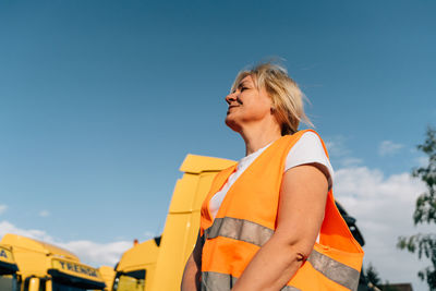 Smiling businesswoman under blue sky