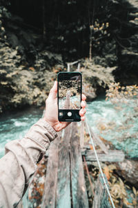 Wide angle fpv of hiker photographing bridge with smartphone