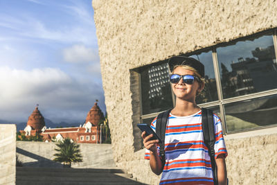 Portrait of smiling young man against built structure