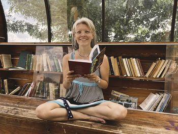 Portrait of young woman reading book