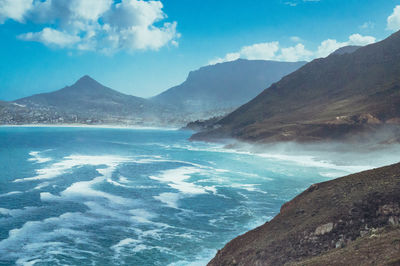 Scenic view of sea and mountains against sky