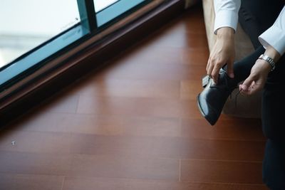 Low section of man holding hands on floor