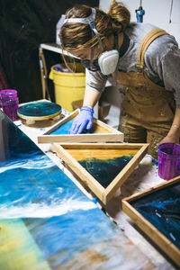 Female resin working in homemade studio