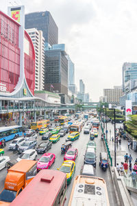 Traffic on city street by buildings against sky