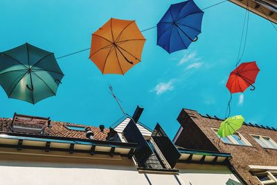 Low angle view of umbrellas on roof against sky