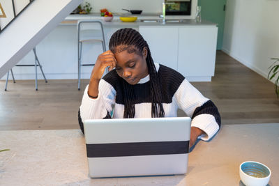 Side view of man using mobile phone while sitting at home