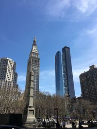 Low angle view of skyscrapers against cloudy sky