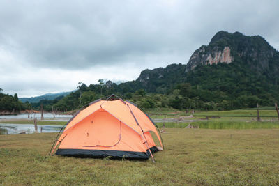 Tent on field by mountain against sky