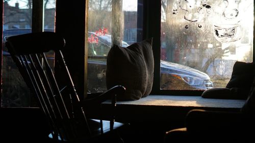 Empty chairs and table by window