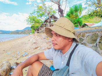 Portrait of young woman sitting at beach