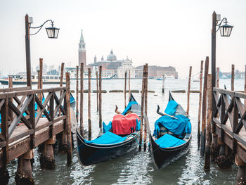 Boats moored on sea against church