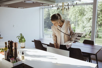 Woman with magazine examining dining furniture at new property