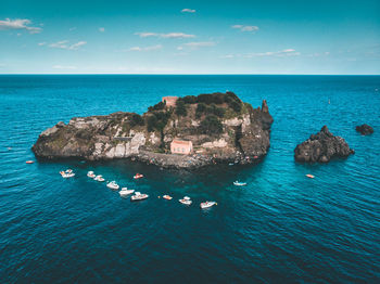 High angle view of rocks in sea against blue sky