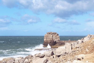 Scenic view of rocks on beach against sky