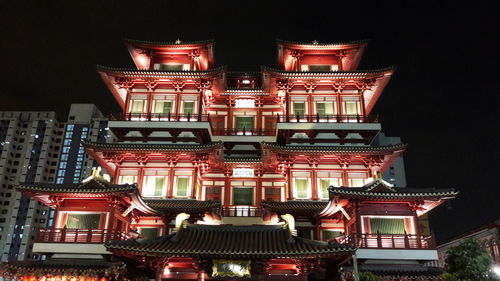 Low angle view of illuminated building against sky at night