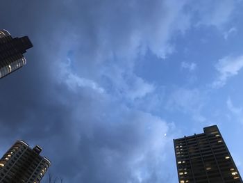 Low angle view of buildings against cloudy sky
