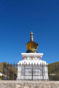 Low angle view of bell tower against blue sky