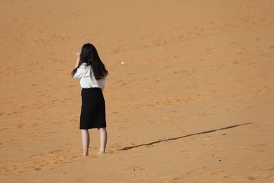 Rear view of woman walking on beach