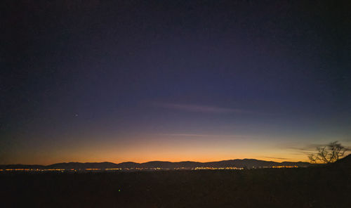Scenic view of silhouette field against sky at sunset