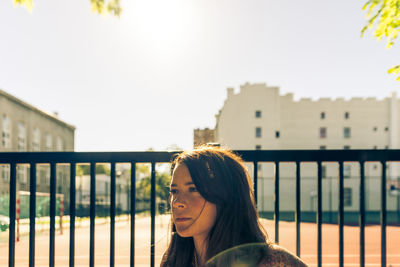 Portrait of smiling young woman standing against sky