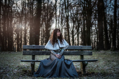 Woman sitting on bench in forest