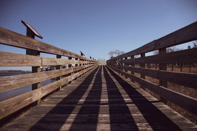Empty railway bridge against clear blue sky