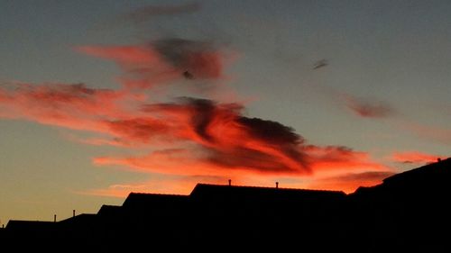 Silhouette of building against dramatic sky