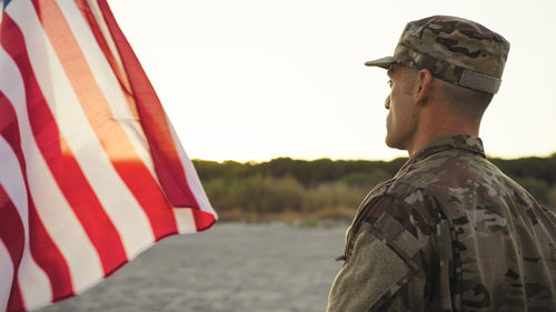 Military man in uniform in front of an american flag