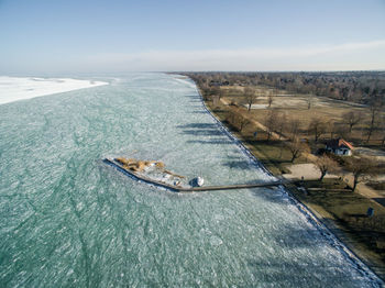 High angle view of harbor at frozen river against clear sky