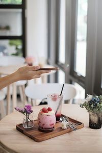 Hand holding ice cream cone on table