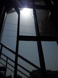 Low angle view of sunlight streaming through window in building