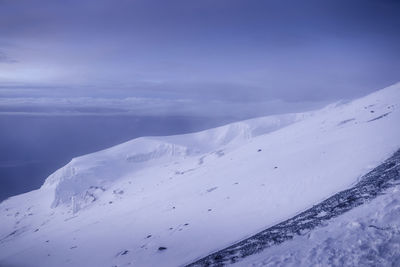 Scenic view of snow covered mountains against sky