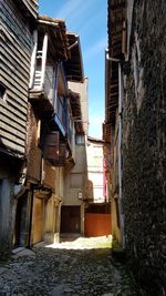 Low angle view of narrow alley amidst old buildings