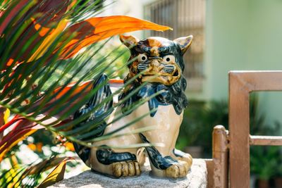 Close-up of cat figurine on retaining wall