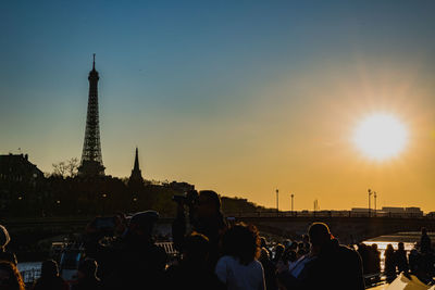 People in city against sky during sunset