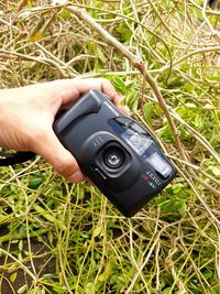 Close-up of person photographing camera on plant