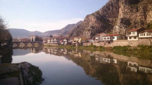 Houses by lake in town against sky