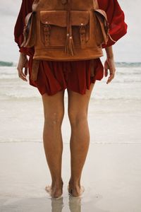 Low section of man standing on beach