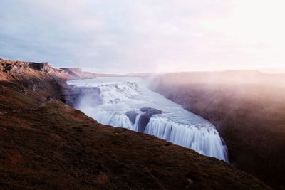 Scenic view of waterfall against sky