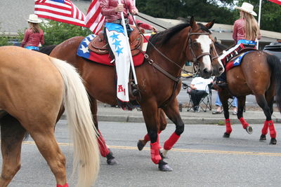 Men horses on street