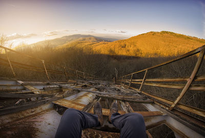 Low section of man on mountain against sky